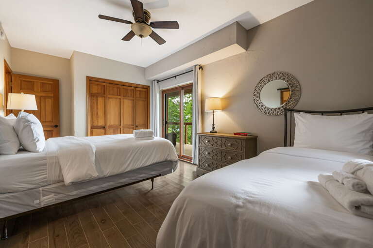 Sink into crisp white linens and let the gentle ceiling fan breeze lull you to sleep in your serene twin bedroom retreat.