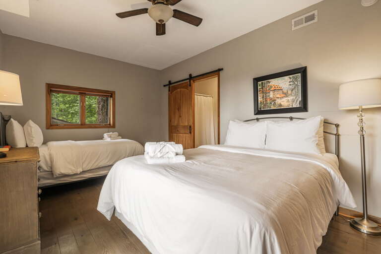 Sink into crisp linens and enjoy your peaceful retreat with rustic barn door charm and garden views.