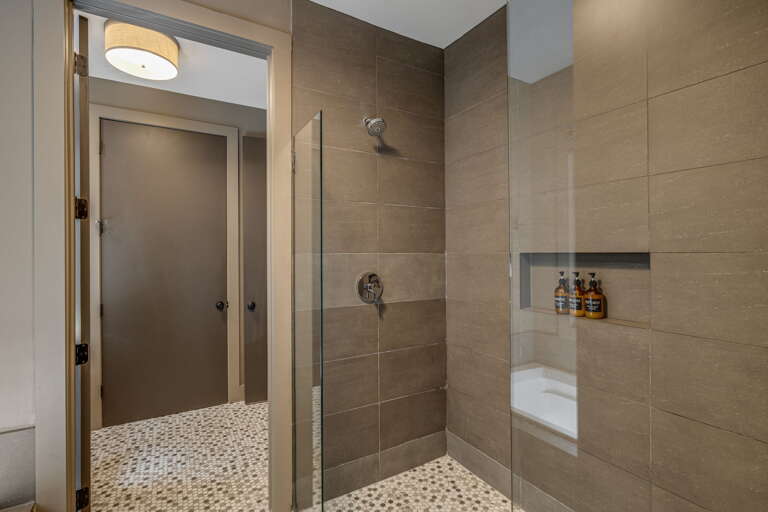 Step into your private spa-like shower, where sleek tile surrounds you and luxury toiletries await in a built-in niche—your peaceful retreat after every adventure.