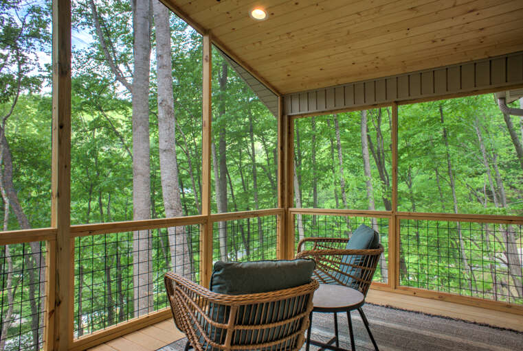 Covered Deck with Outdoor Seating and Wooded Surroundings
