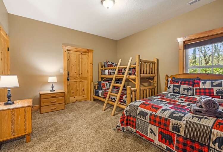 Your cozy rustic bedroom features warm wood furnishings and playful plaid bedding perfect for family adventures.
