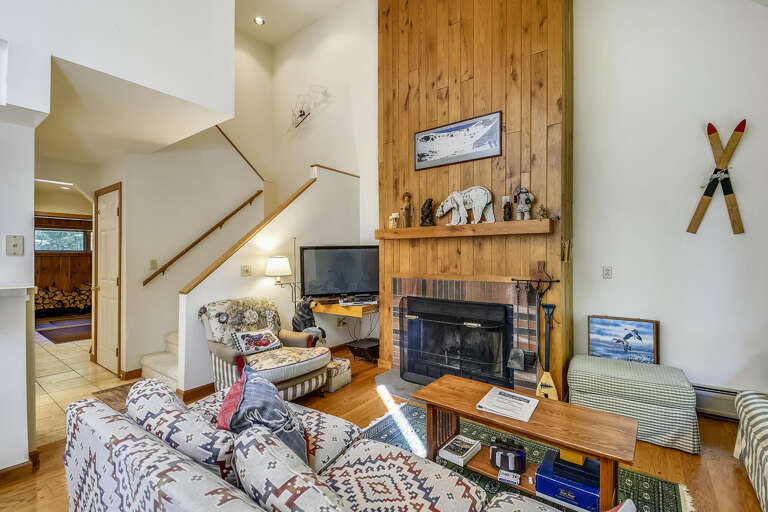 Living Space With Fireplace, Staircase, And Wooden Wall Accents