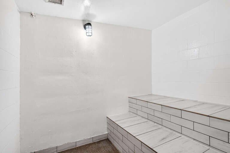 White-walled Room With Tiered Seating Steps And Single Ceiling Lamp