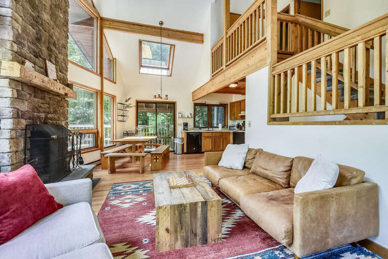 Spacious Living Space With Soaring Ceilings, Stone Hearth, And Wooden Balustrades