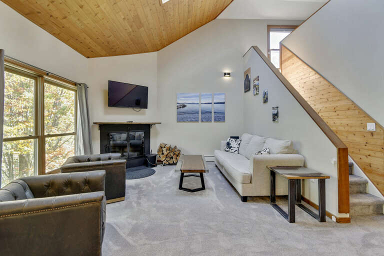 Bright, Spacious Living Space With Lofted Ceiling, Large Windows And A Leafy View