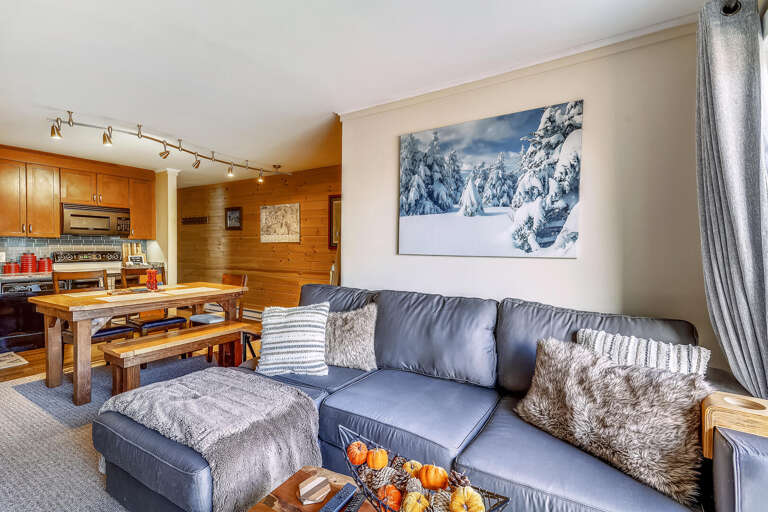 Living Space With Sectional Sofa, Kitchen Area, And Mountain Picture