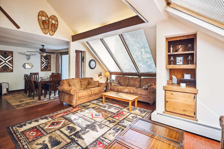 Spacious Living Space With Sloped Ceilings, Skylights, And Rustic Furnishings