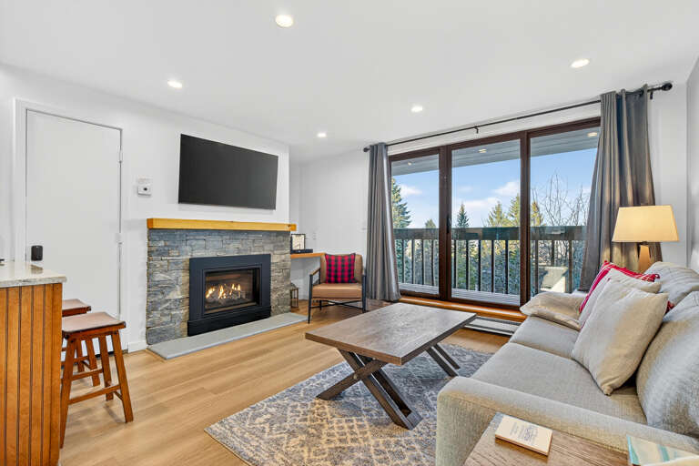 Living Room With Fireplace, Window View, And Seating Area In Vacation Rental