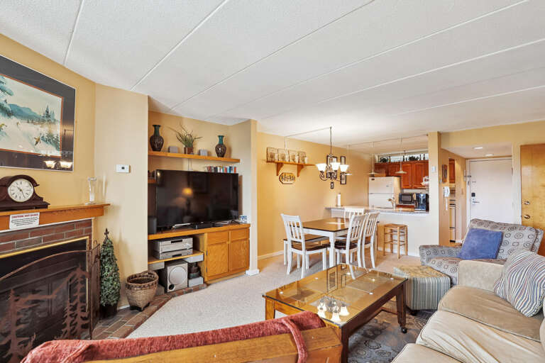 Spacious Living Space With Connected Kitchen, Comfortable Couch, And Large TV