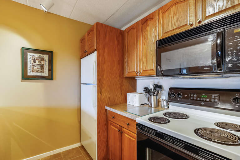 Kitchen Corner With Wooden Cabinets And White Appliances