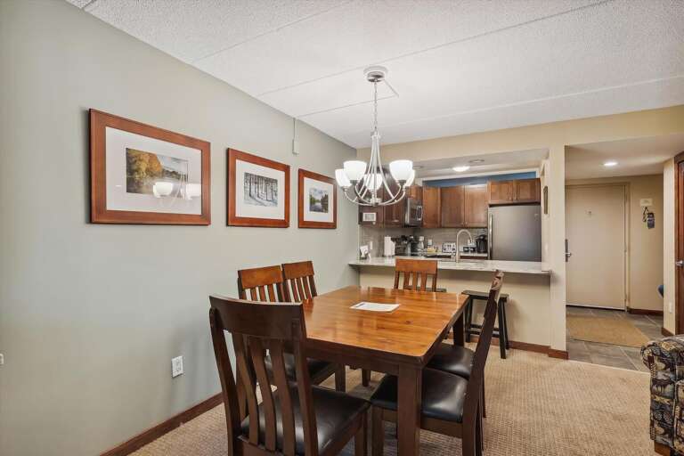 Interior Dining Space With Wooden Table, Chairs, And Kitchen In View