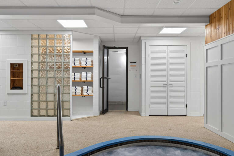 Indoor Space With A Trampoline, White Walls, Wood Accents, And Glass Blocks