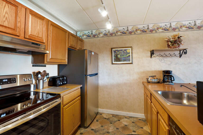 Vacation Rental Kitchen With Wooden Cabinets And Stainless Steel Appliances