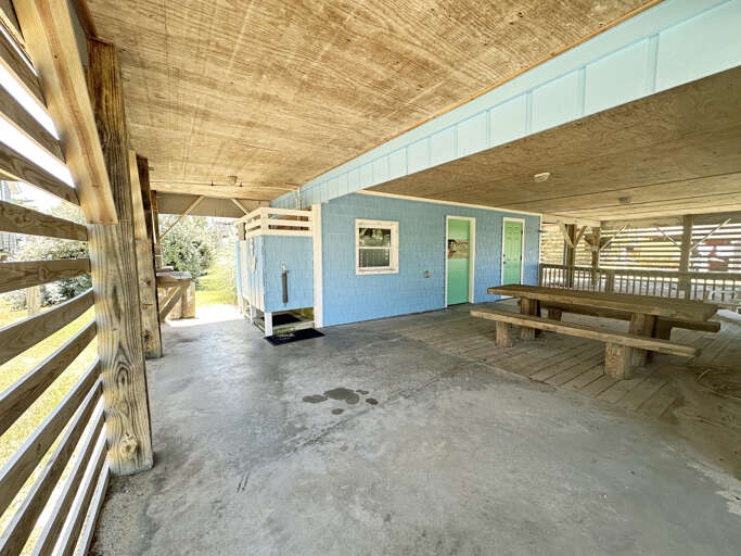 Covered Porch Area With Benches And Blue Doors