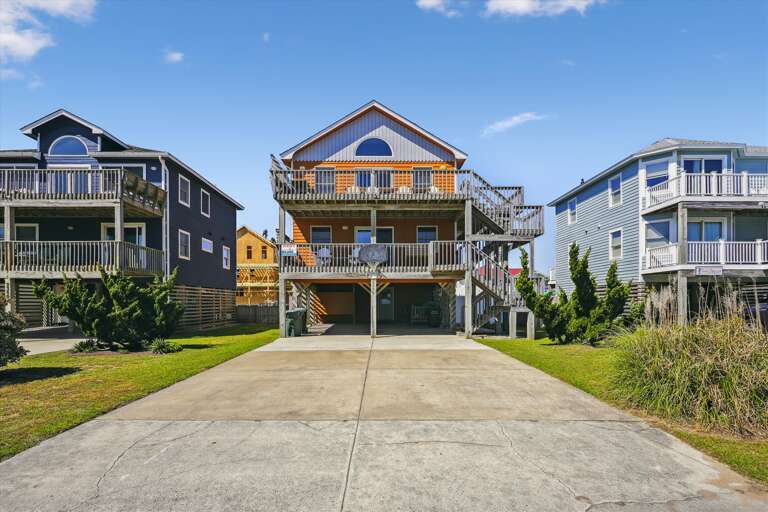 Three-story Building With Balconies And Surrounding Residences Under Blue Sky Three-story Building With Balconies And Surrounding Residences Under Blue Sky
