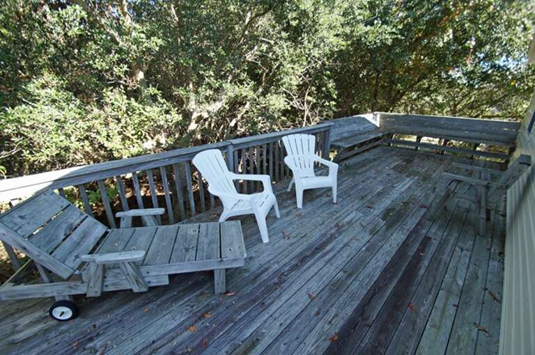 Wooden Balcony With Chairs And Surrounding Trees