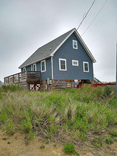 Blue House With Deck On Grassy Terrain Blue House With Deck On Grassy Terrain