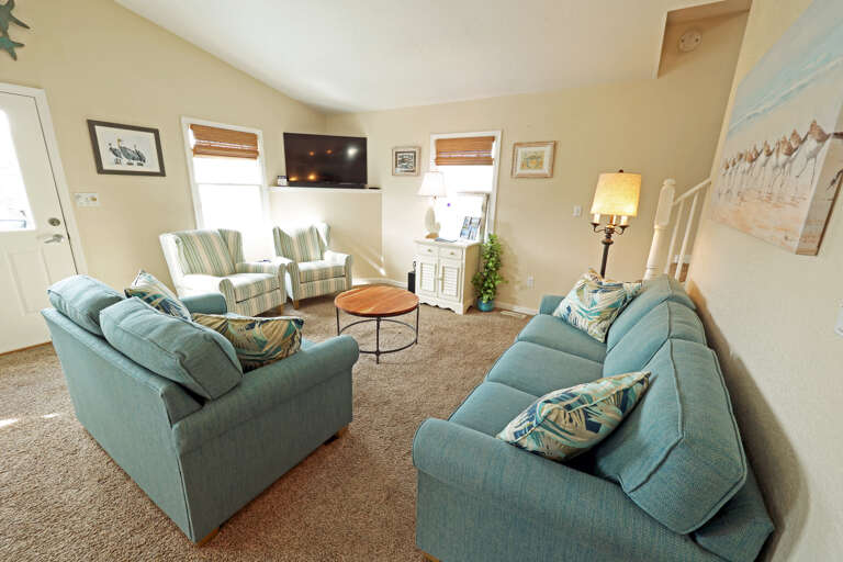 Living Room In A Vacation Rental With Blue Sofas And A Coffee Table