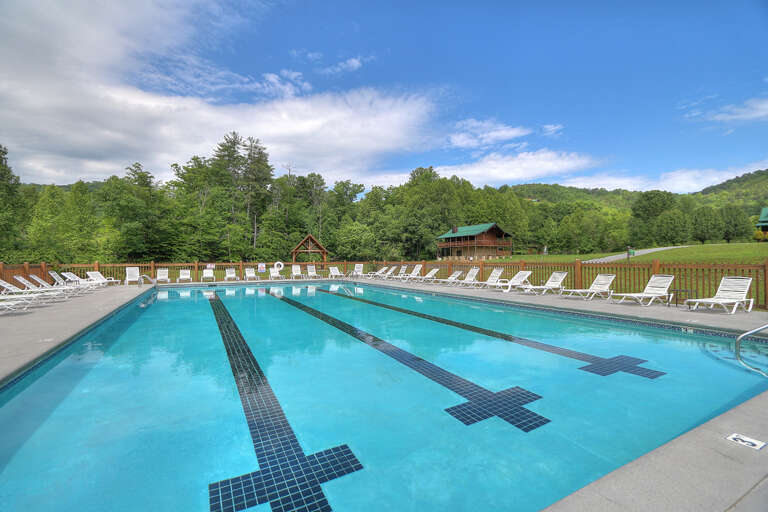 Blue Pool Flanked By White Chairs, Lush Green Landscape Backdrop
