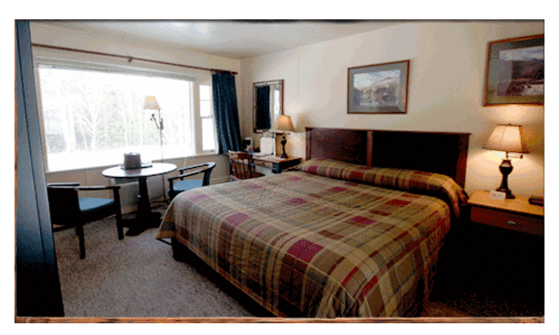 Cozy Bedroom With Plaid Comforter, Lamps, And Artwork