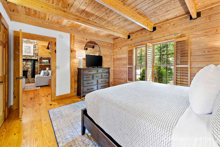 The master bedroom has a large dresser and a tv