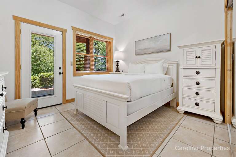 On the lower level there is a bedroom with a queen bed and a door to the outdoors