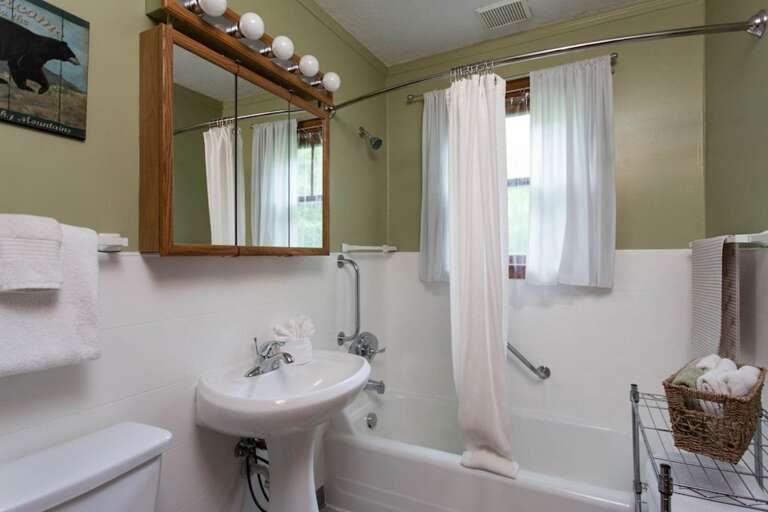 The home has a full bath with a pedestal sink and bathtub/shower combination