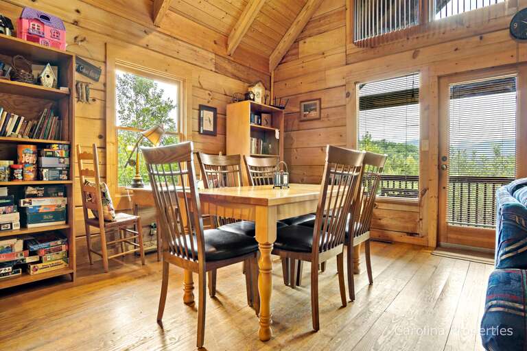 There are board games and books located on the shelves in the dining room