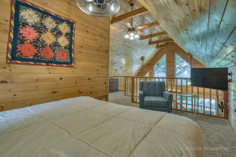 Loft with bed, seat, and TV