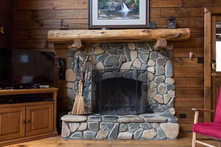 The wood-burning stone fireplace is the focal point of this area