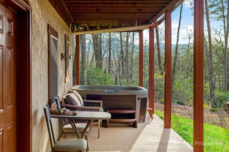 The lower deck has a seating area and a hot tub The lower deck has a seating area and a hot tub