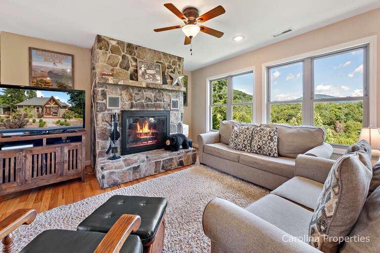 Living room features a large stone fireplace and a gorgeous view Living room features a large stone fireplace and a gorgeous view