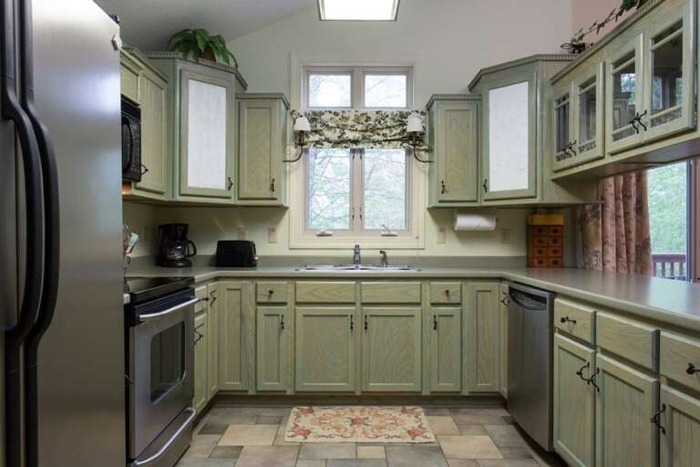 Just past the door is the fully equipped kitchen complete with stainless steel appliances including a side-by-side refrigerator.