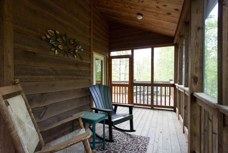 A door leads to the open sun part of the deck and a 4-person dining set.