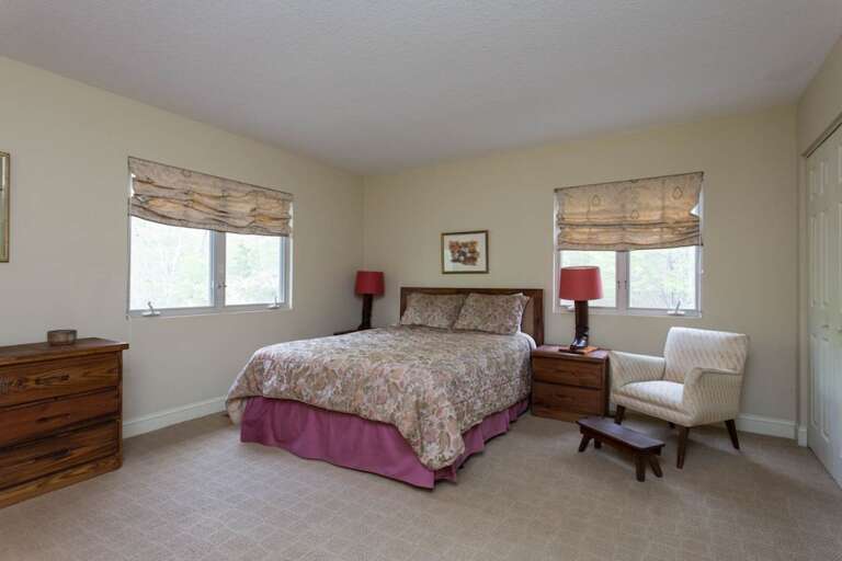 The queen bed suite is spacious and features windows and a comfortable chair. The queen bed suite is spacious and features windows and a comfortable chair.