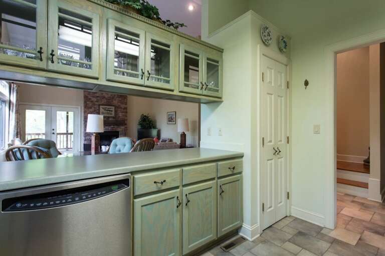 While it is not completely open to the dining and living areas, there is an open space between the counter and glass-door overhead cabinets. While it is not completely open to the dining and living areas, there is an open space between the counter and glass-door overhead cabinets.