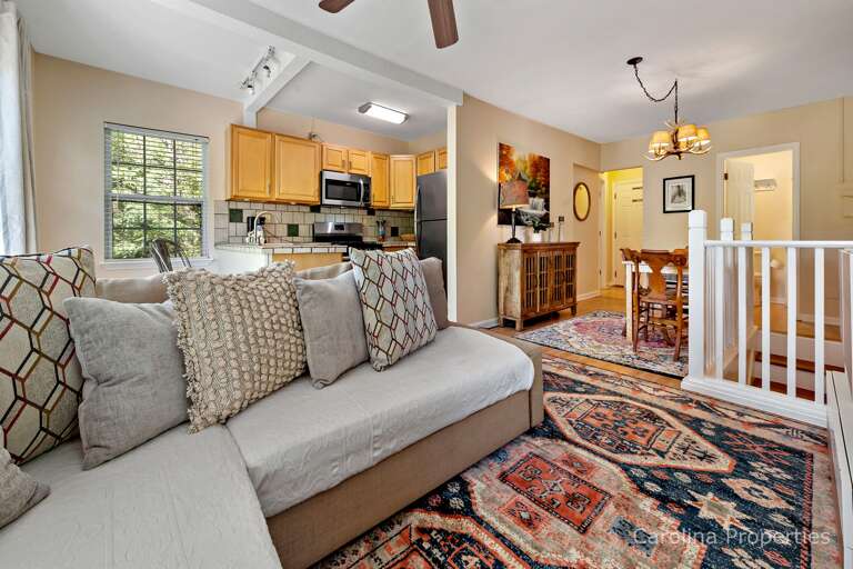 The open living spaces include the kitchen, living room and dining area