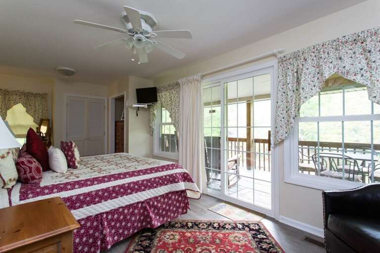 The windows along the wall of the room includes a sliding door for access to the lakeside deck.