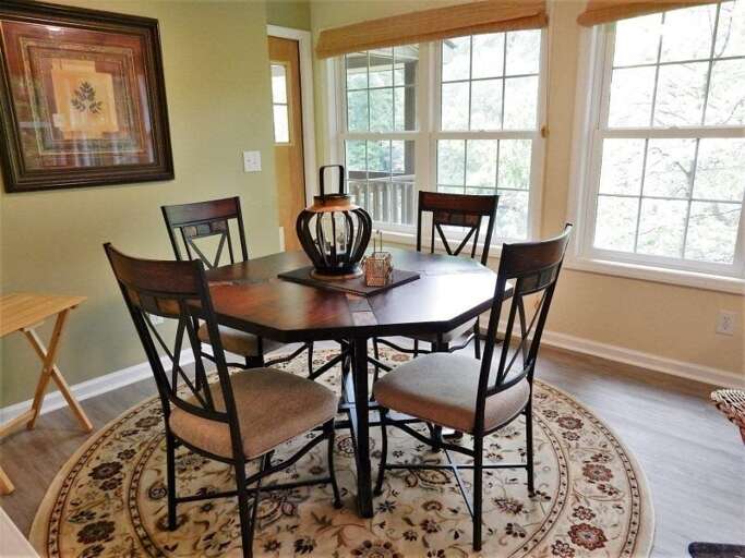 A door near the dining table, which seats 4, leads to a lakeside deck. A door near the dining table, which seats 4, leads to a lakeside deck.