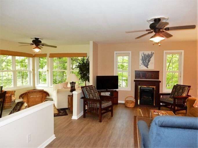 The living area features a gas fireplace. The warm wood floors are throughout the home.