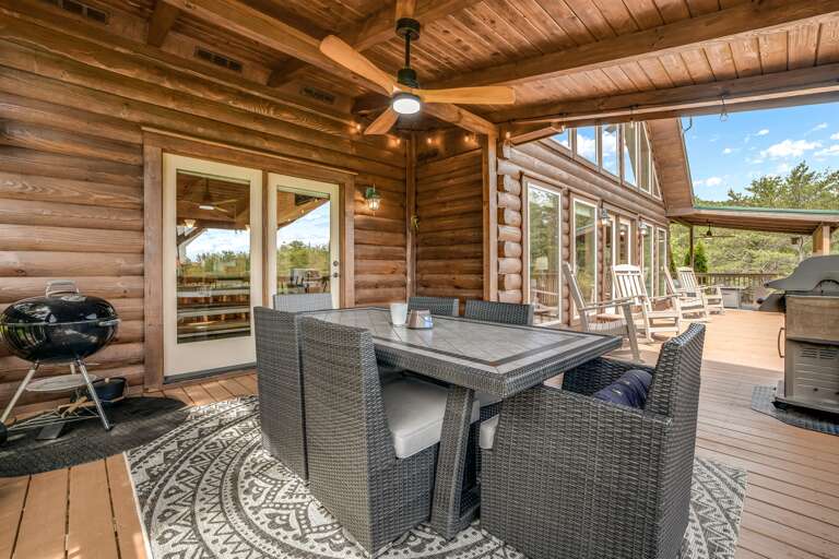 Outdoor dining area featuring seating for 6, and a gas and charcoal grills.