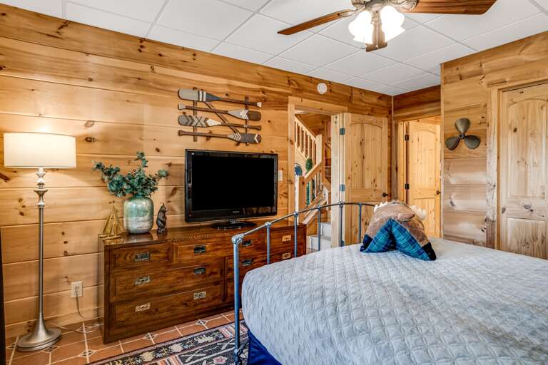 Lower level bedroom with a queen bed and a TV