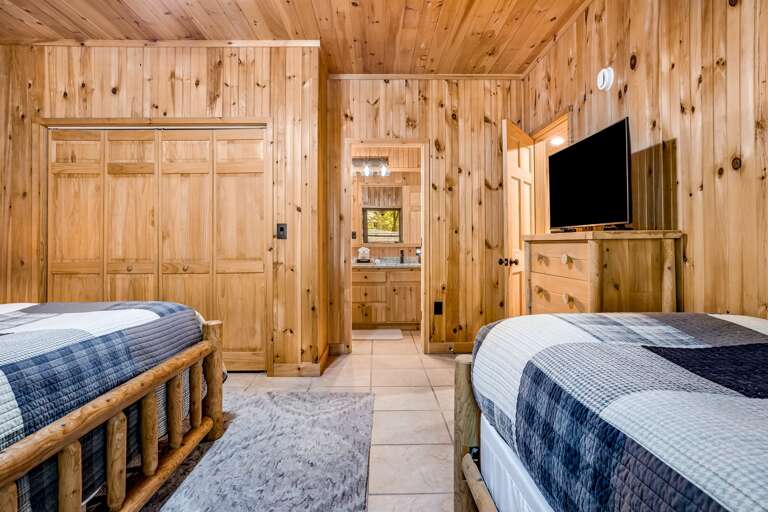 Bedroom with king and twin bed has a Tv and dresser