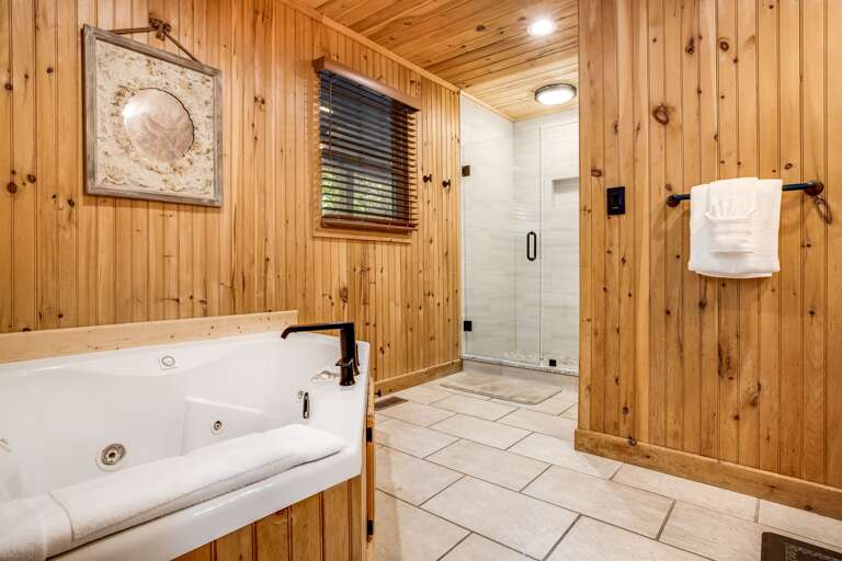 Main level bathroom features a large tub and walk-in shower