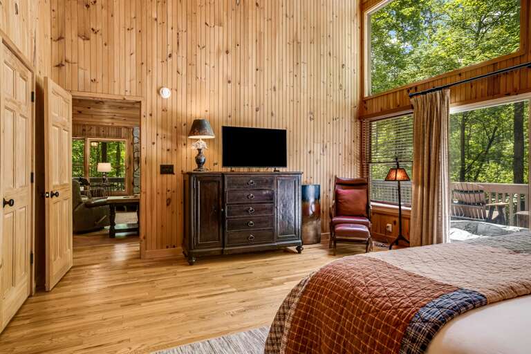 The main level bedroom has a tv and access to the deck