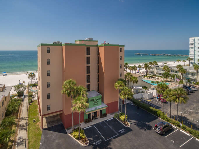 Beachfront property showcasing direct beach access, swimming pool, and convenient parking in a tropical coastal setting.