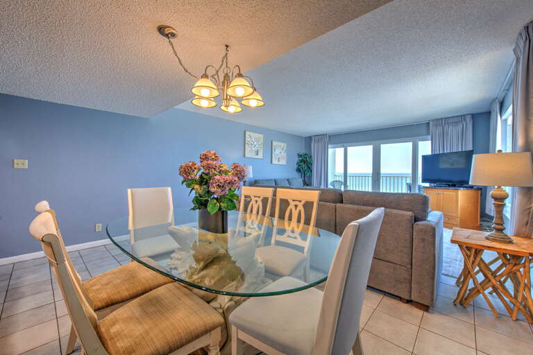 Your elegant dining space features a glass table for memorable meals with ocean views through panoramic windows.