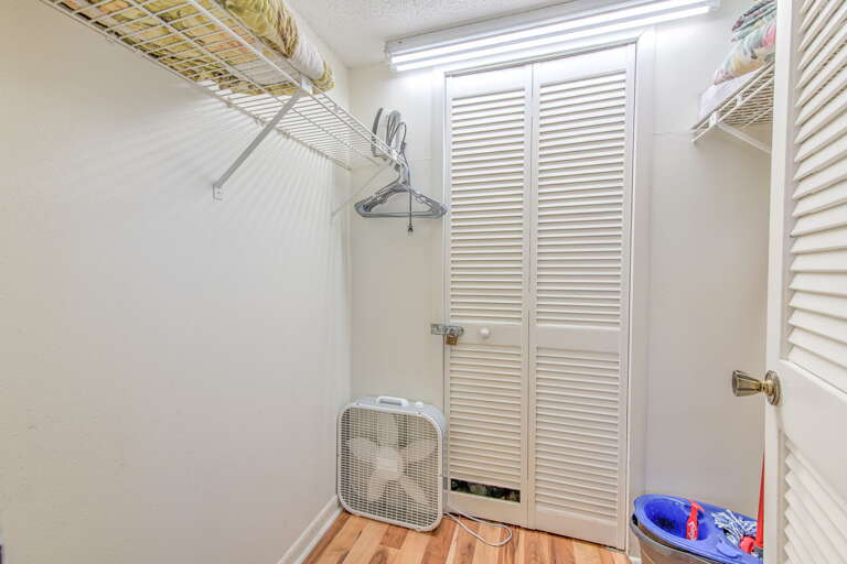 Your walk-in closet offers organized storage with wire shelving, hanging space, and a convenient fan for air circulation during your stay.