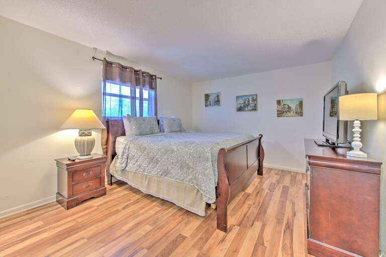 Relax in your peaceful bedroom featuring warm wood furnishings, soft lighting, and charming artwork creating the perfect retreat for restful nights.