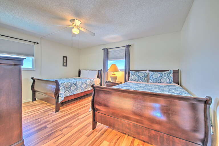 Relax in your spacious bedroom with two comfortable beds, warm hardwood floors, and gentle ceiling fan keeping you cool.